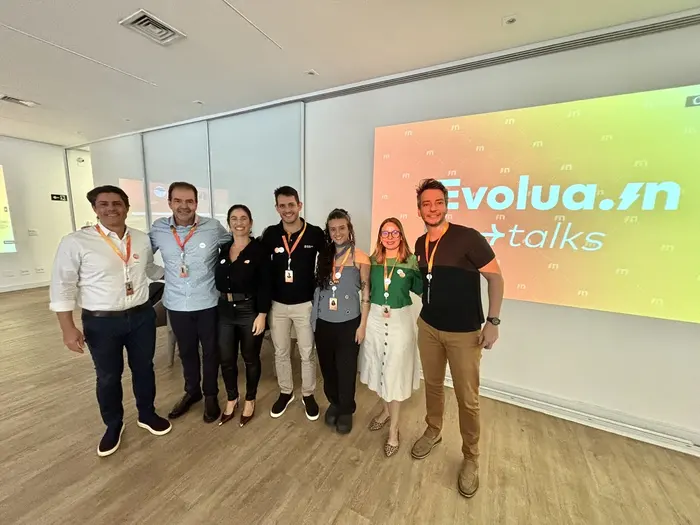 Equipe em frente ao telão do Evolua.in Talks